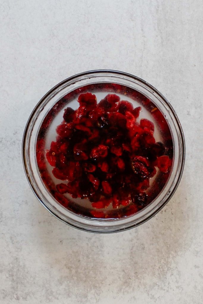 A bowl of dried cranberries rehydrating in boiling water.