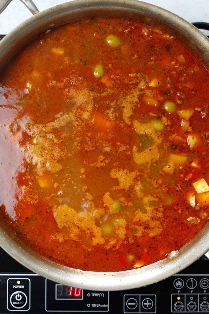 Picadillo simmering in a large skillet.