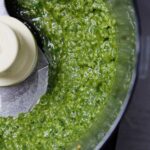 Homemade basil pesto sauce in a food processor.