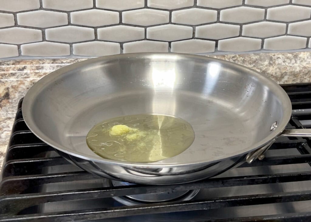 Melting clarified butter in a large stainless-steel skillet.