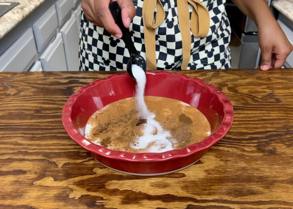 Sprinkling sugar into brioche french toast custard.