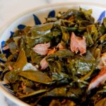 Collard greens with smoked turkey necks in a blue bowl.