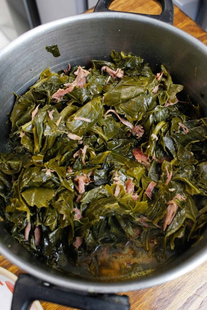 Collard greens with smoked turkey necks in a large pot.