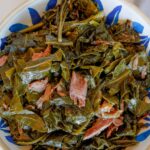 Collard greens with smoked turkey necks in a blue bowl.