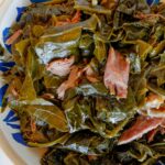 Collard greens with smoked turkey necks in a blue bowl.