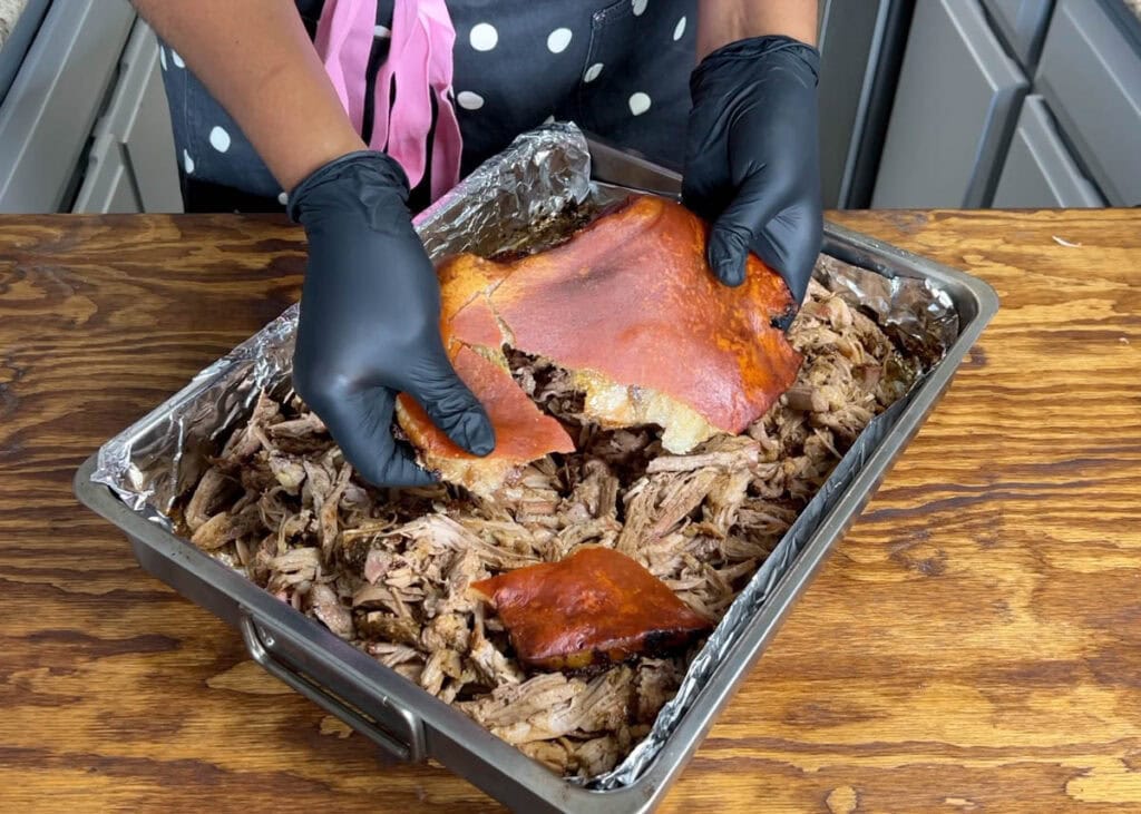 Breaking crispy pernil skin, called "cuero".