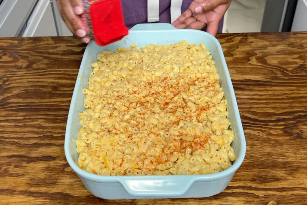 Sprinkling smoked paprika on mac and cheese.