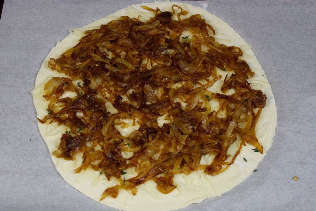 A puff pastry circle sprinkled with caramelized onions, Gruyere cheese and thyme.