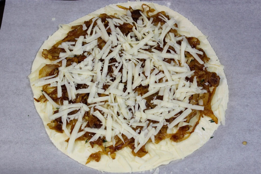 A puff pastry circle sprinkled with caramelized onions, Gruyere cheese and thyme.