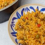 Arroz con gandules in a caldero and a blue and white plate.