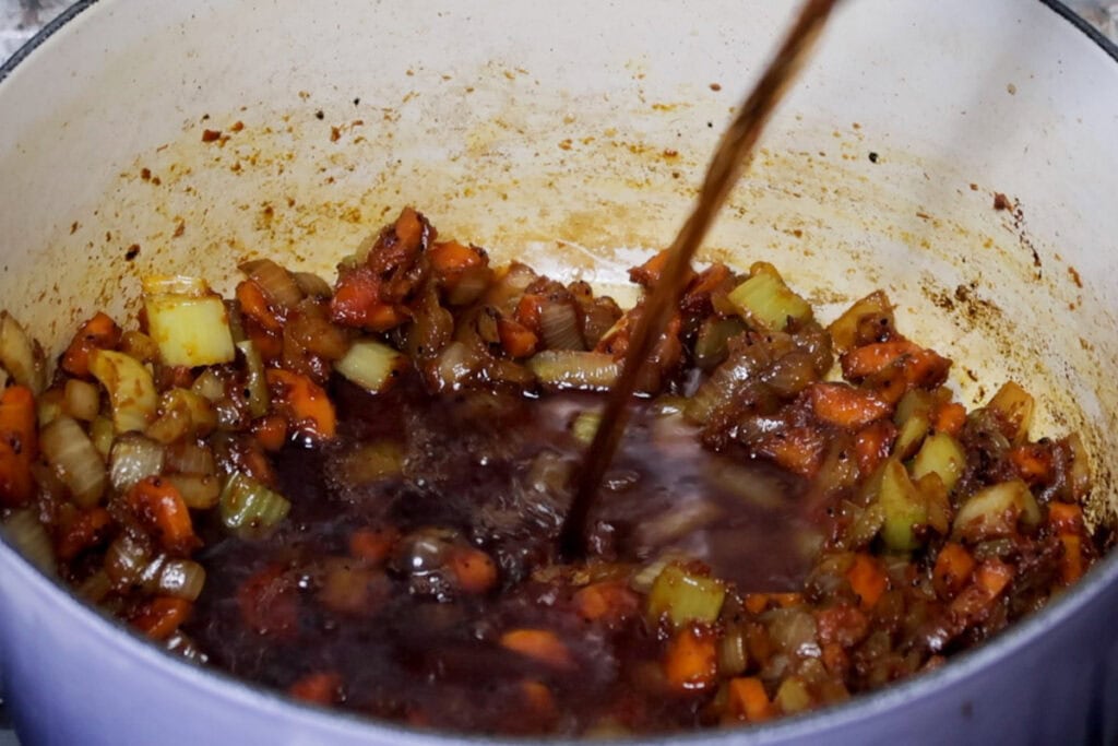 Deglazing the dutch oven with red wine.