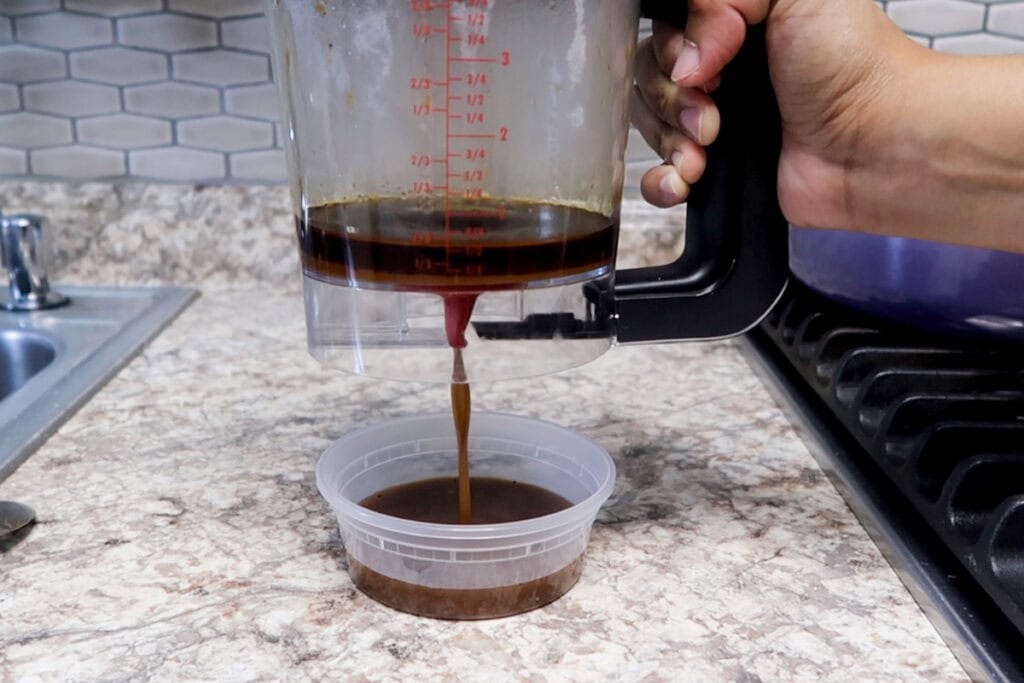 Straining and degreasing short ribs sauce.