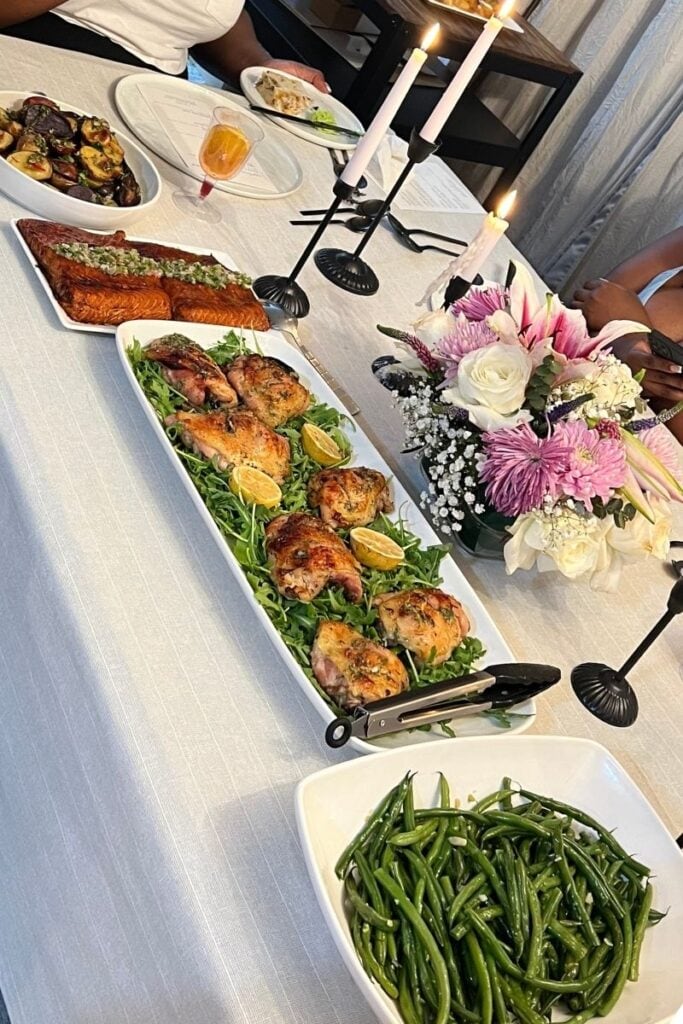 Dinner party spread of green beans, mediterranean chicken thighs, soy glazed salmon with herb salsa, and crispy potatoes.